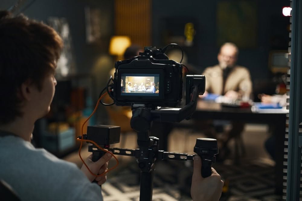 Camera operator filming a podcast interview on a professional monitor
